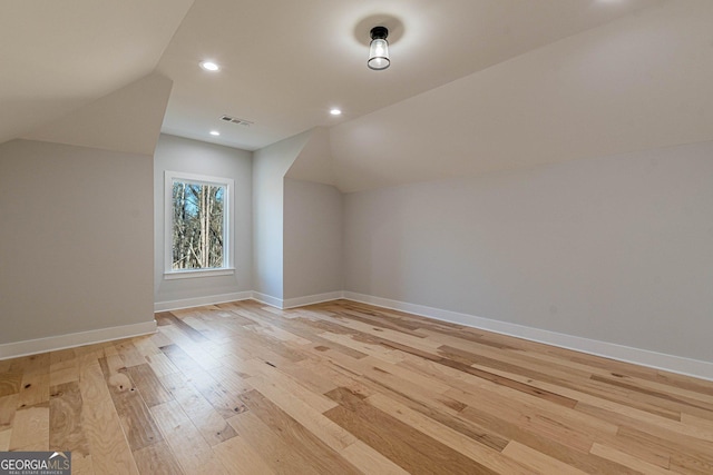 bonus room featuring vaulted ceiling and light hardwood / wood-style floors