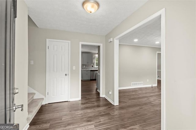 empty room with dark wood-type flooring and a textured ceiling