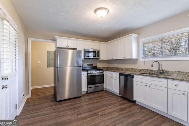 3517 Hyland Dr, Decatur, GA 30032 - kitchen with sink, dark stone countertops, white cabinets, dark hardwood / wood-style flooring, and stainless steel appliances