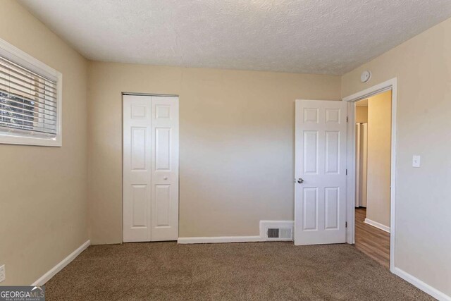 3517 Hyland Dr, Decatur, GA 30032 - unfurnished bedroom with carpet flooring, a textured ceiling, and a closet