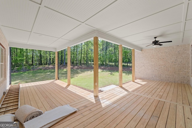 wooden terrace featuring ceiling fan and a lawn