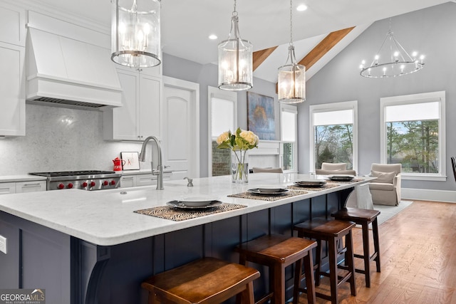 kitchen with white cabinetry, custom exhaust hood, and stove