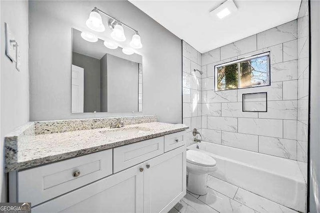 full bathroom featuring tiled shower / bath combo, vanity, and toilet