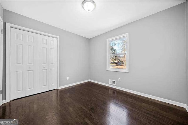 unfurnished bedroom featuring hardwood / wood-style floors and a closet