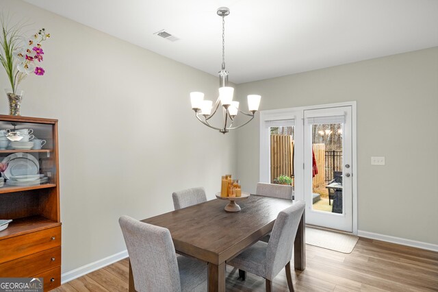 dining room featuring ceiling fan with notable chandelier and light hardwood / wood-style flooring