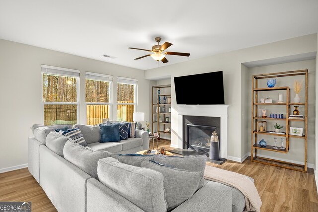 living room with ceiling fan and light hardwood / wood-style flooring