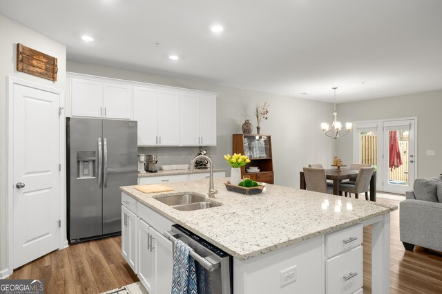 kitchen with stainless steel appliances, sink, a center island with sink, and white cabinets