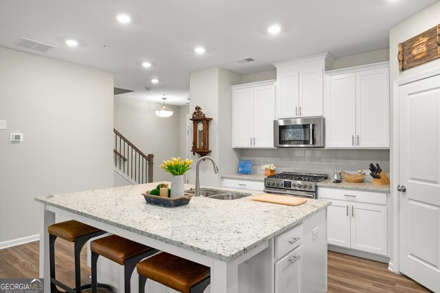 kitchen featuring a kitchen island with sink, sink, white cabinetry, and stainless steel appliances