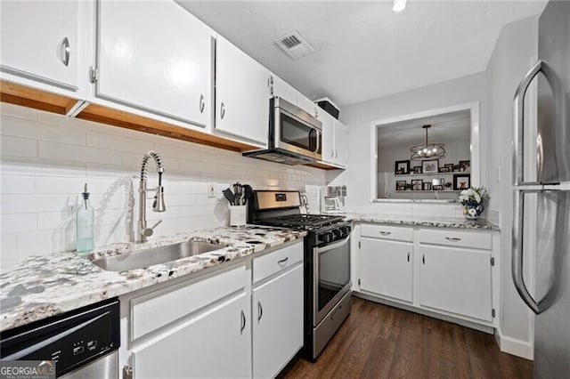 kitchen with visible vents, appliances with stainless steel finishes, white cabinets, and a sink