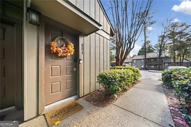 property entrance featuring a residential view and board and batten siding