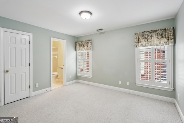 unfurnished bedroom with light carpet and ensuite bath