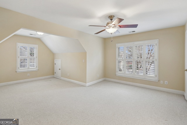 additional living space with light carpet, lofted ceiling, and ceiling fan