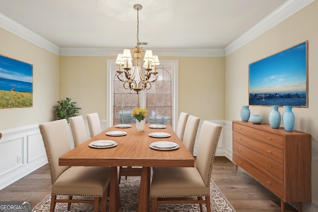 dining area featuring a notable chandelier, ornamental molding, and dark hardwood / wood-style floors