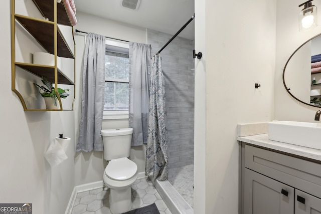 bathroom featuring vanity, tile patterned flooring, toilet, and walk in shower