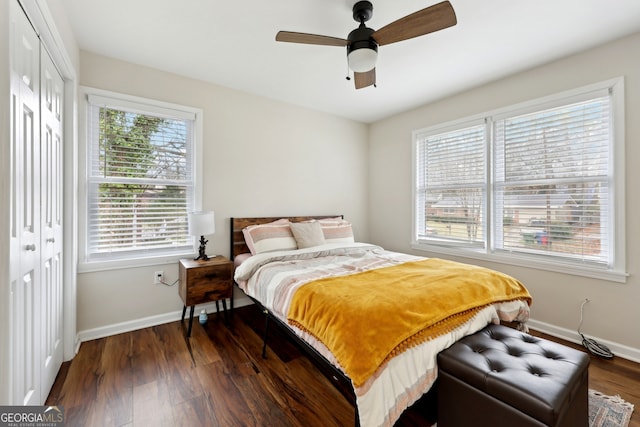 bedroom featuring dark wood-type flooring, ceiling fan, and a closet