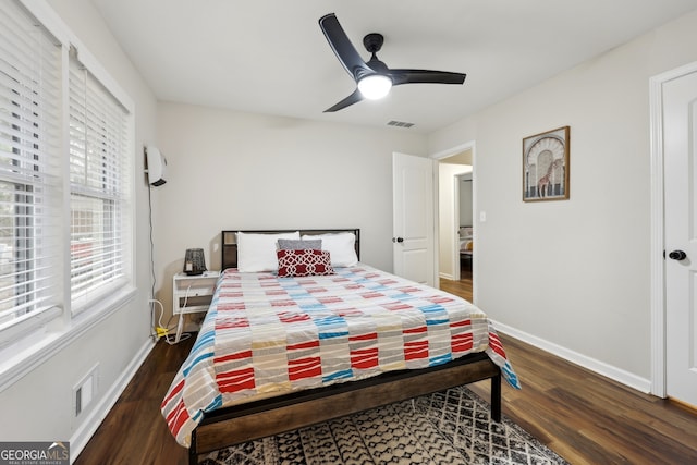 bedroom featuring ceiling fan, a wall mounted air conditioner, and dark hardwood / wood-style floors