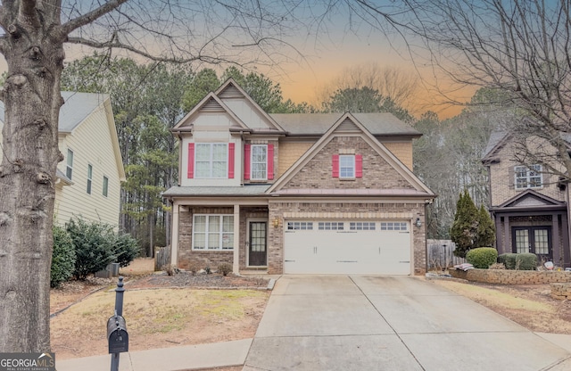 craftsman house featuring a garage, brick siding, and concrete driveway