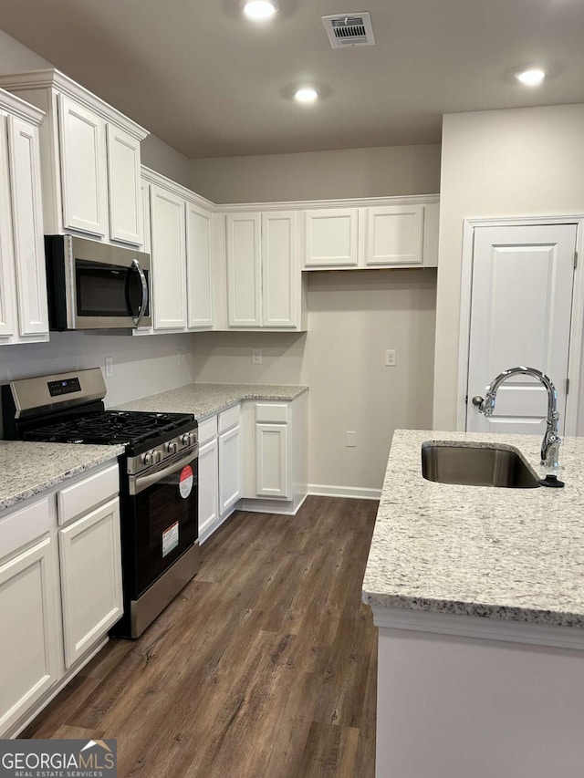 16 Wildflower Ln Unit 39, Dallas, GA 30132 - kitchen featuring stainless steel appliances, white cabinets, dark wood-style floors, light stone counters, and recessed lighting