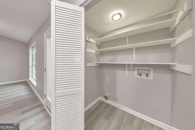 laundry room with gas dryer hookup, washer hookup, and light hardwood / wood-style floors