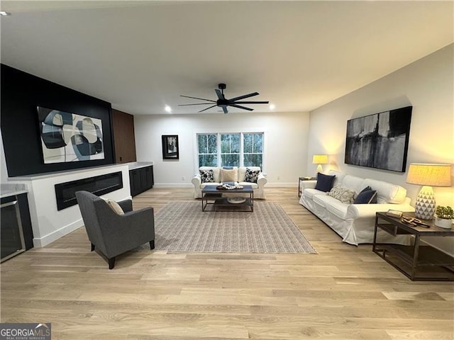 living room with ceiling fan and light hardwood / wood-style floors