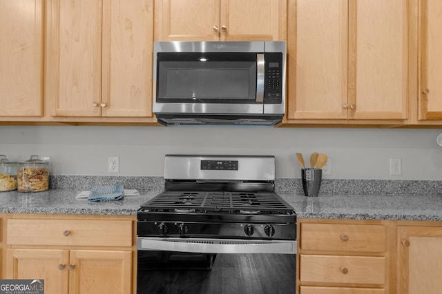 kitchen with appliances with stainless steel finishes, light brown cabinets, and light stone counters