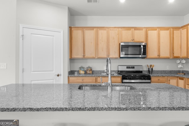 kitchen featuring visible vents, light brown cabinets, appliances with stainless steel finishes, and a sink