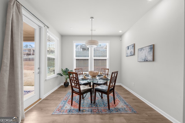 dining room with visible vents, baseboards, and wood finished floors