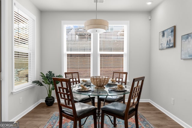 dining room with visible vents, plenty of natural light, baseboards, and wood finished floors