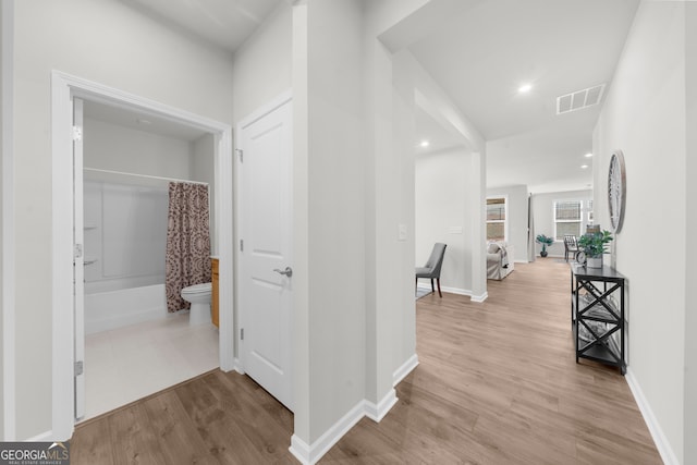 corridor with recessed lighting, visible vents, light wood-style flooring, and baseboards