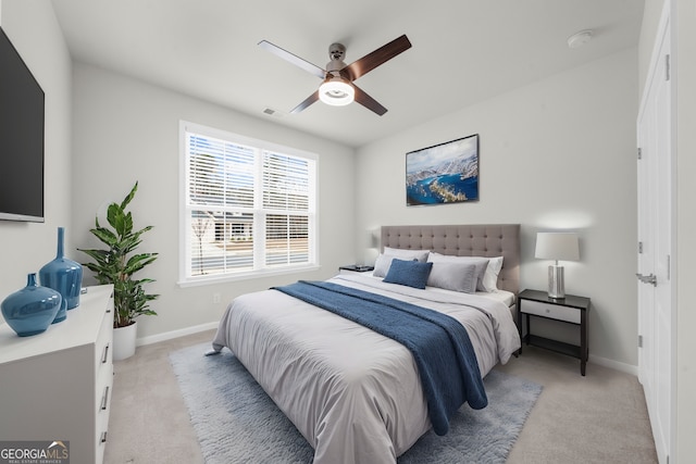 bedroom with light carpet, ceiling fan, visible vents, and baseboards