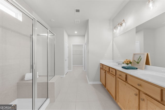 full bath featuring tile patterned flooring, a sink, a shower stall, and double vanity