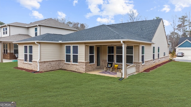 rear view of property with a yard, brick siding, and a shingled roof