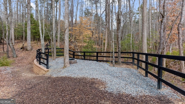 view of yard featuring fence and a forest view