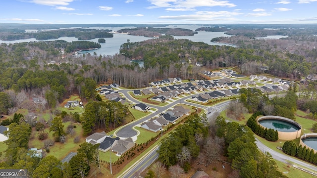 drone / aerial view featuring a residential view, a water view, and a forest view