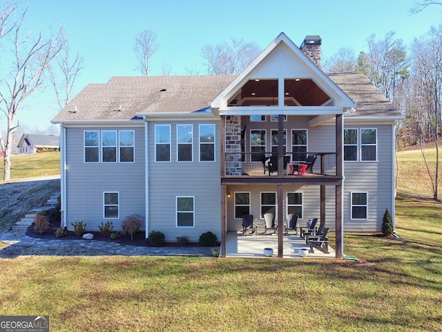 back of house featuring a lawn, a patio, and a balcony