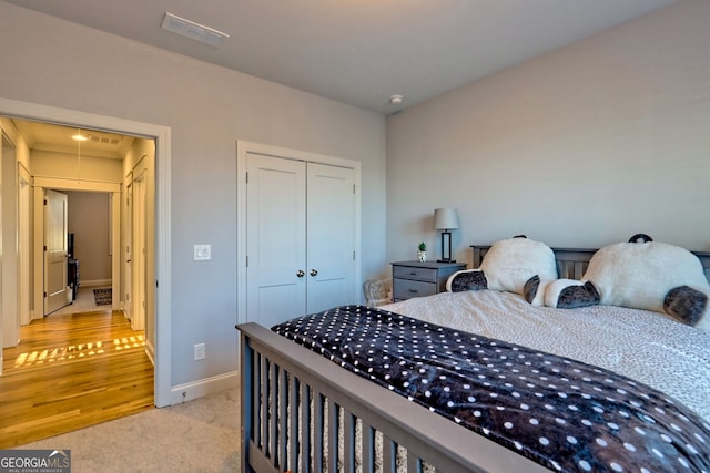 bedroom featuring light carpet and a closet