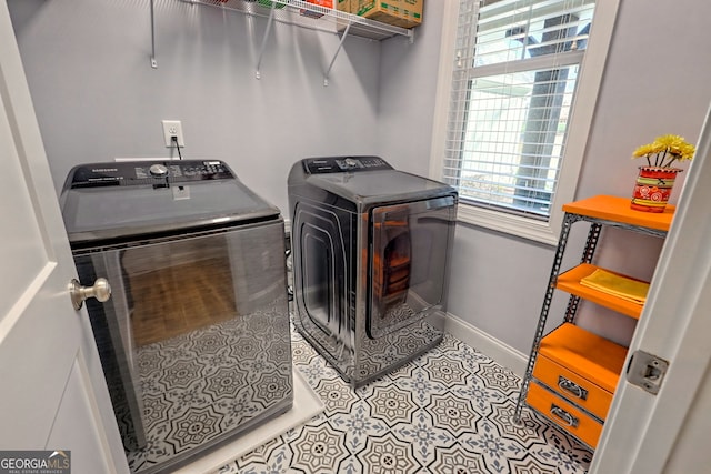 laundry area with washer and clothes dryer and light tile patterned floors