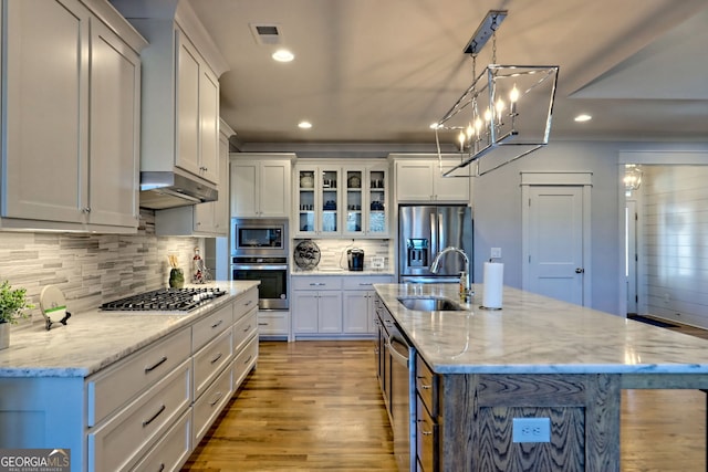 kitchen with a kitchen island with sink, appliances with stainless steel finishes, sink, and white cabinets