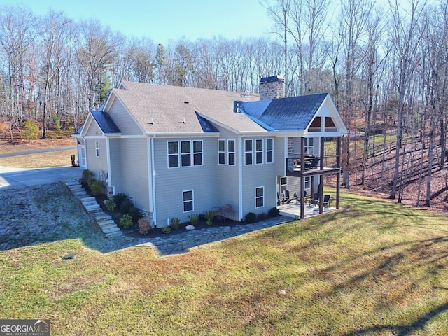 rear view of property with a patio area and a lawn