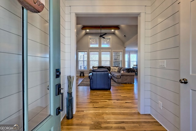 hall featuring beamed ceiling, wood-type flooring, and high vaulted ceiling