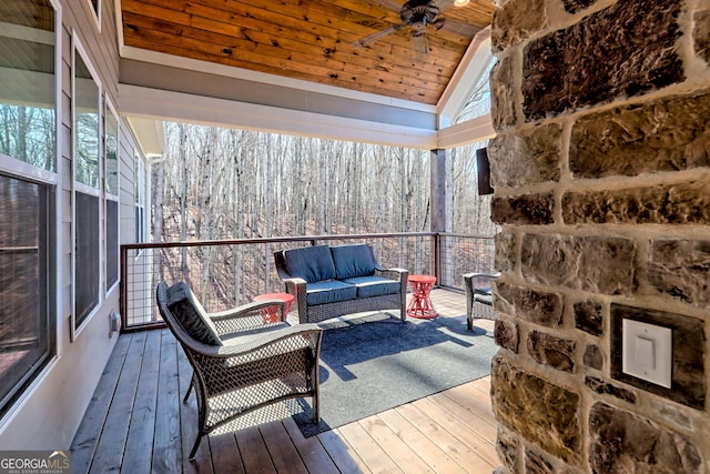 sunroom / solarium featuring vaulted ceiling, wooden ceiling, and ceiling fan