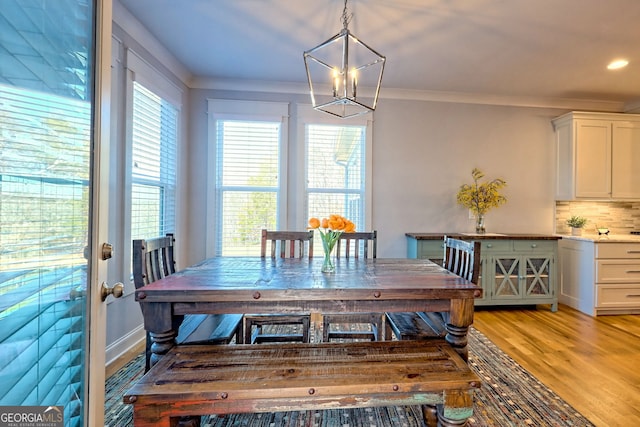 dining room featuring ornamental molding, a chandelier, and light hardwood / wood-style floors