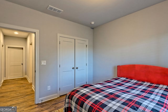 bedroom with light hardwood / wood-style floors and a closet