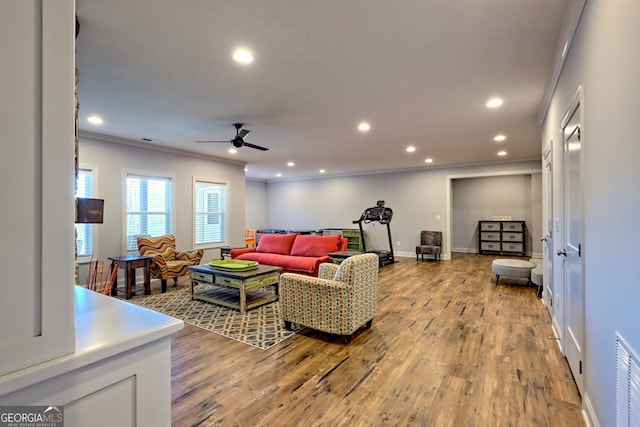 living room featuring crown molding, ceiling fan, and light hardwood / wood-style floors