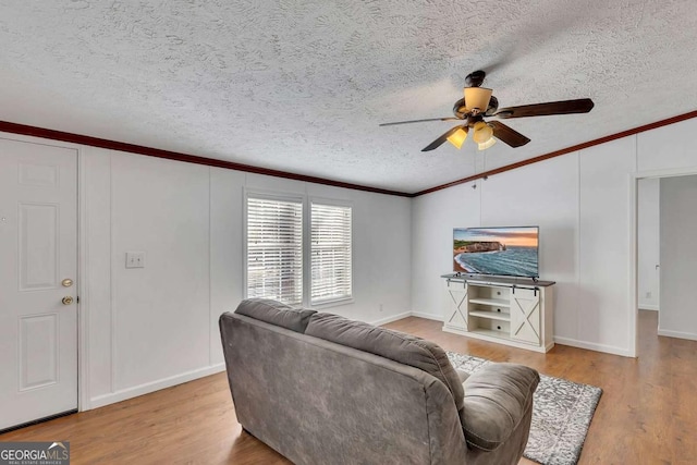 living room featuring crown molding, vaulted ceiling, light hardwood / wood-style flooring, a textured ceiling, and ceiling fan