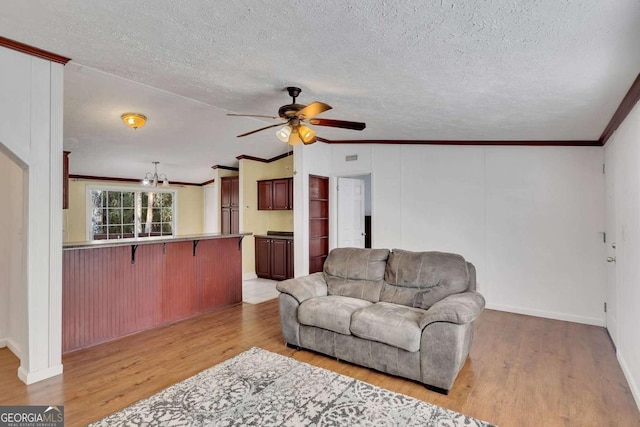 living room featuring crown molding, lofted ceiling, ceiling fan with notable chandelier, and light wood-type flooring