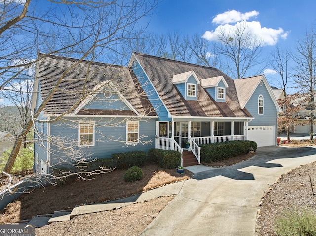 new england style home with a garage, driveway, a porch, and roof with shingles