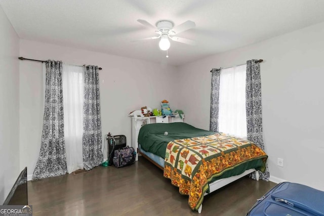 bedroom with dark wood-type flooring and ceiling fan