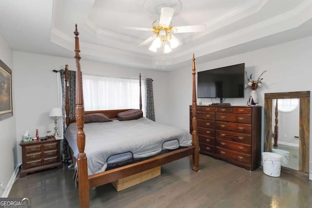 bedroom featuring dark wood-type flooring, ceiling fan, ornamental molding, and a raised ceiling