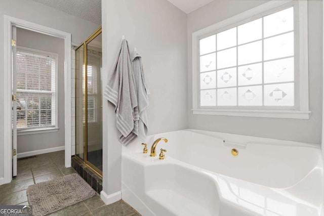 bathroom featuring tile patterned floors, a healthy amount of sunlight, separate shower and tub, and a textured ceiling